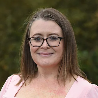 Head-and-shoulders portrait of Lucia Hiden, Head of Communications for the NHS Retirement Fellowship, smiling in front of a blurred outdoor background.