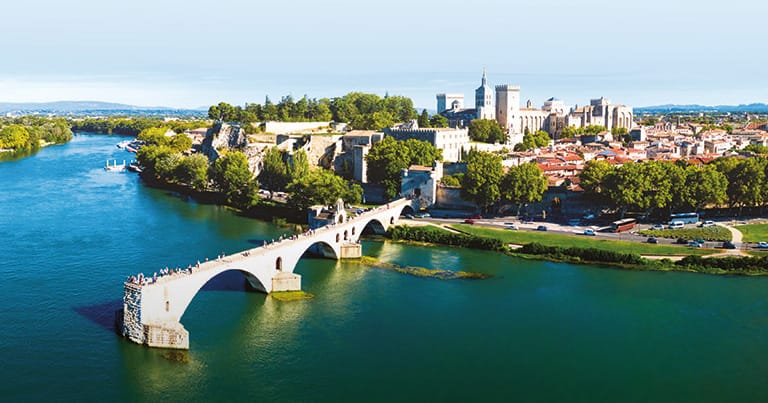 Landscape photograph of the River Rhône in France against the backdrop of a historic town.