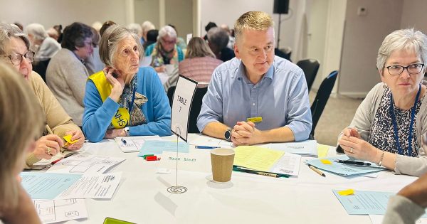 Mark Bailey, new chair of the board of Trustees, and a group of NHS Retirement Fellowship members sat around a table talking at the NHSrf conference